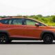 Side view of the 2026 Hyundai Stargazer X in orange, showcasing its new rugged design and black alloy wheels.