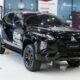 A black Mitsubishi Strada Athlete pickup on display at the MMPC showroom, bearing the UPLB DUNONG Nutri-Nurture Project logo on its doors.